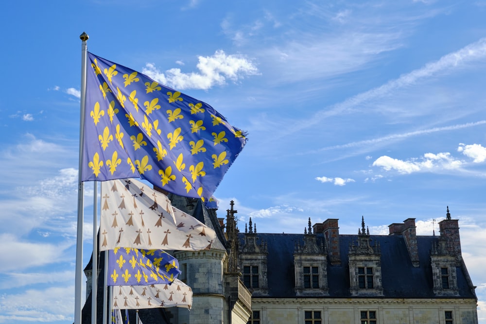 a couple of flags flying in the air in front of a building