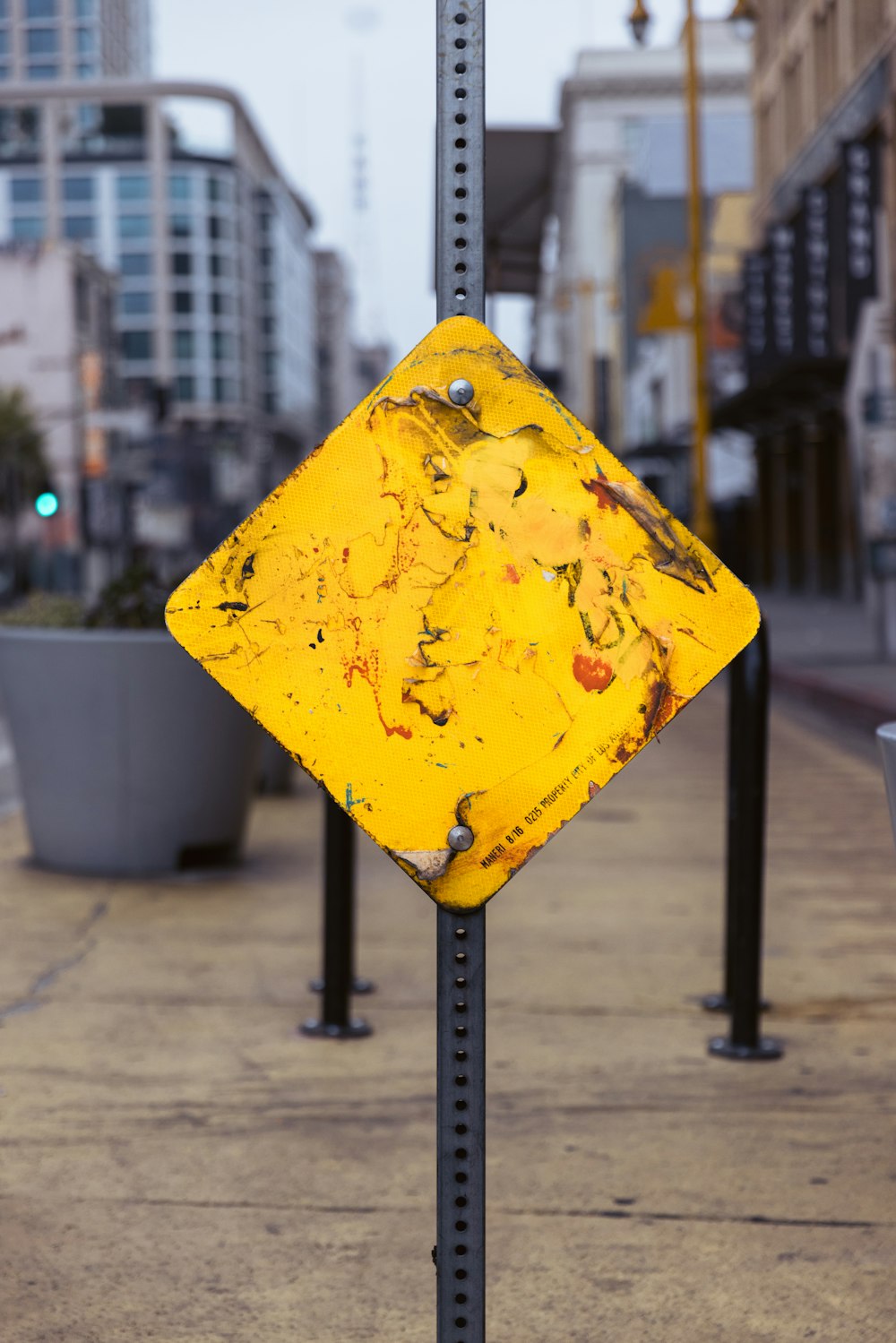 a yellow sign on a sidewalk