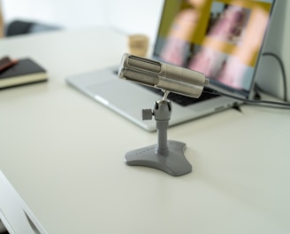 a silver and black stapler on a white surface