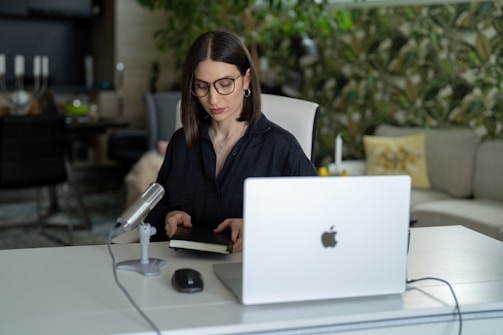 Author Avery Rowan working at a desk with a laptop and notes.