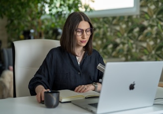 a person sitting at a table with a laptop