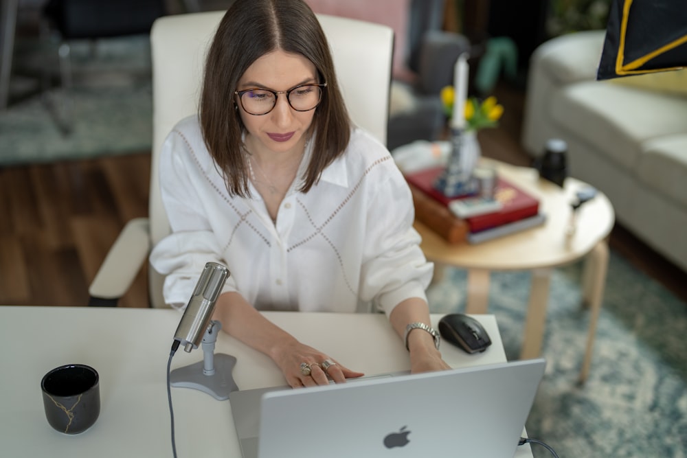 a woman sitting at a table with a laptop