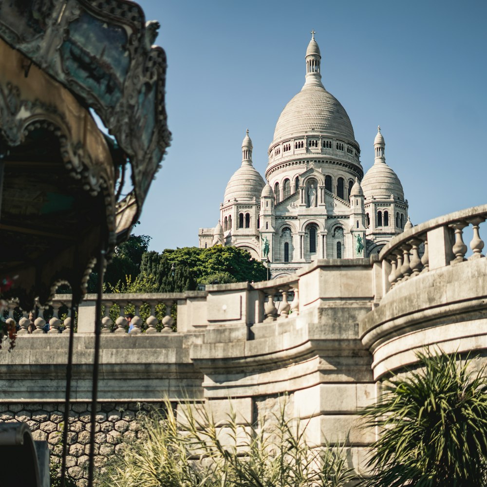 a large white building with domed roofs with Sacré-Cœur, Paris in the background
