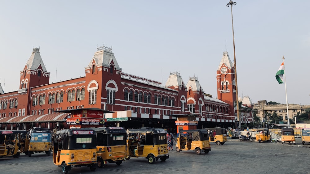 a group of yellow buses parked in front of a building