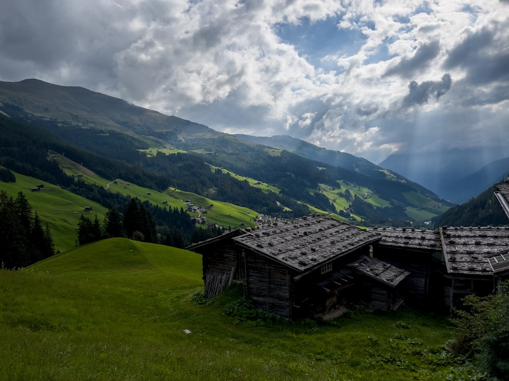 a wooden building on a grassy hill