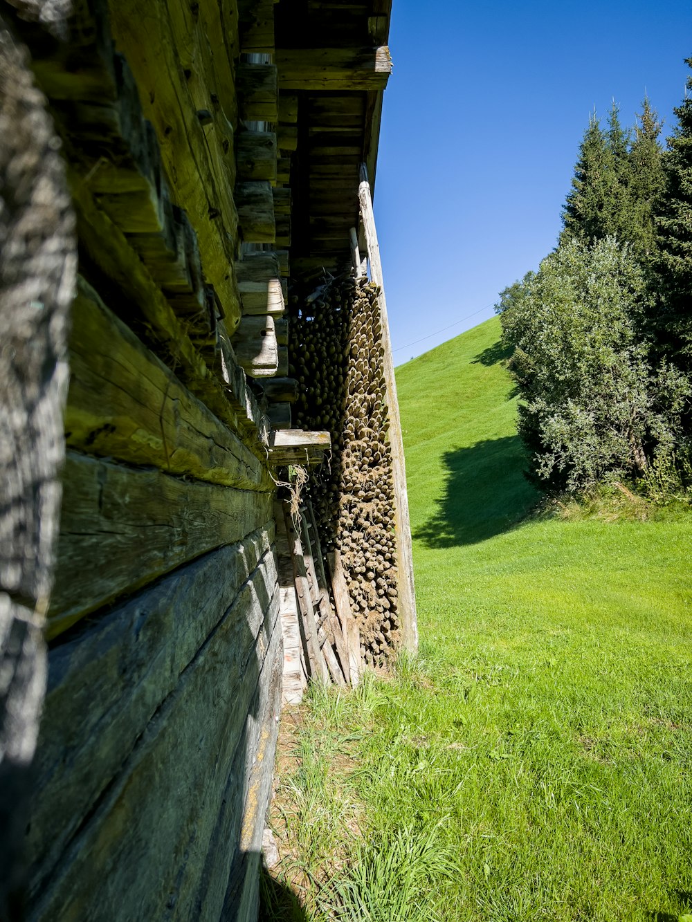 a wooden building with a grass field