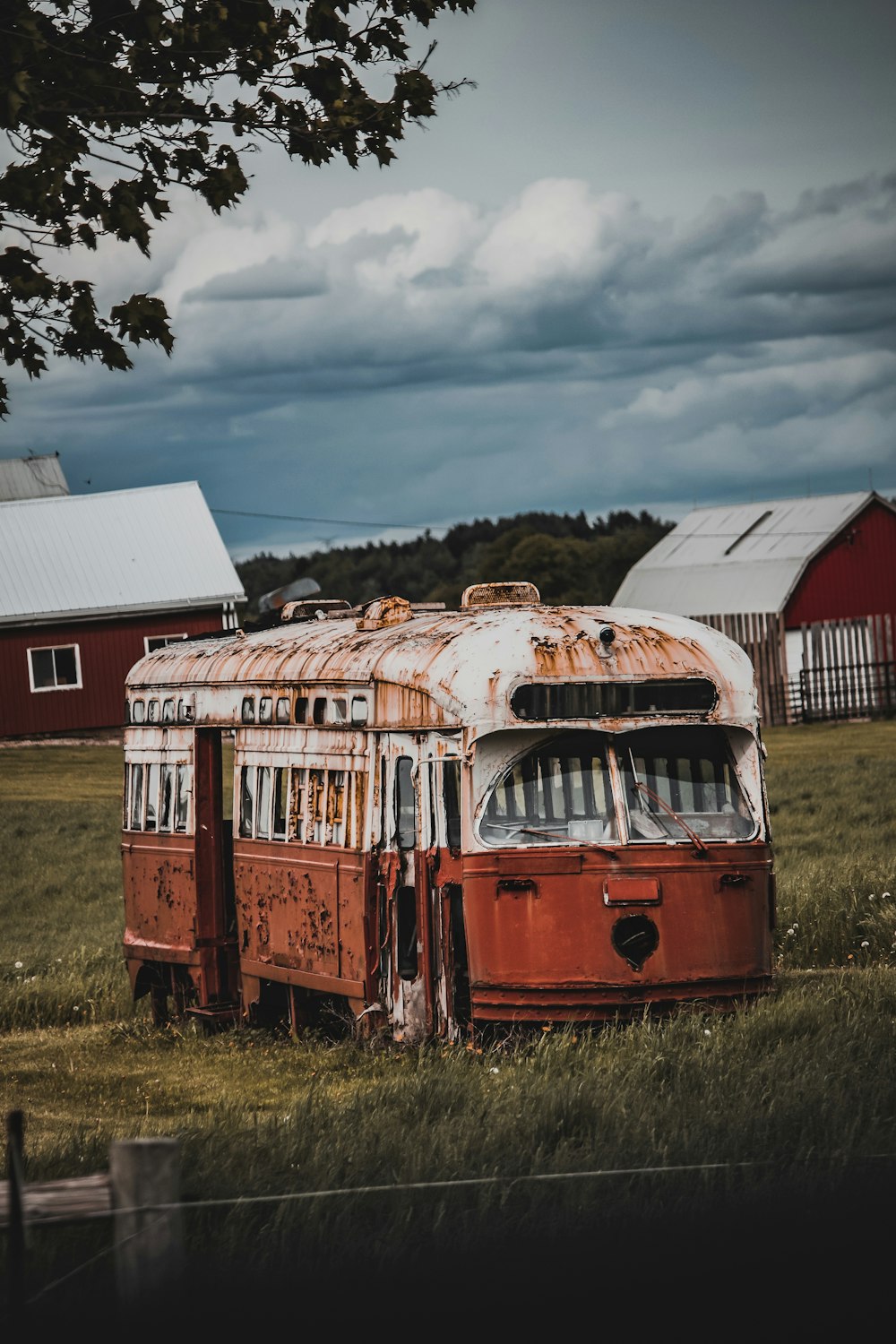 an old rusted out bus in a field