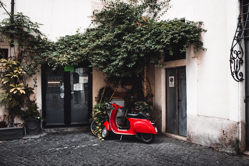 a red scooter parked outside a building
