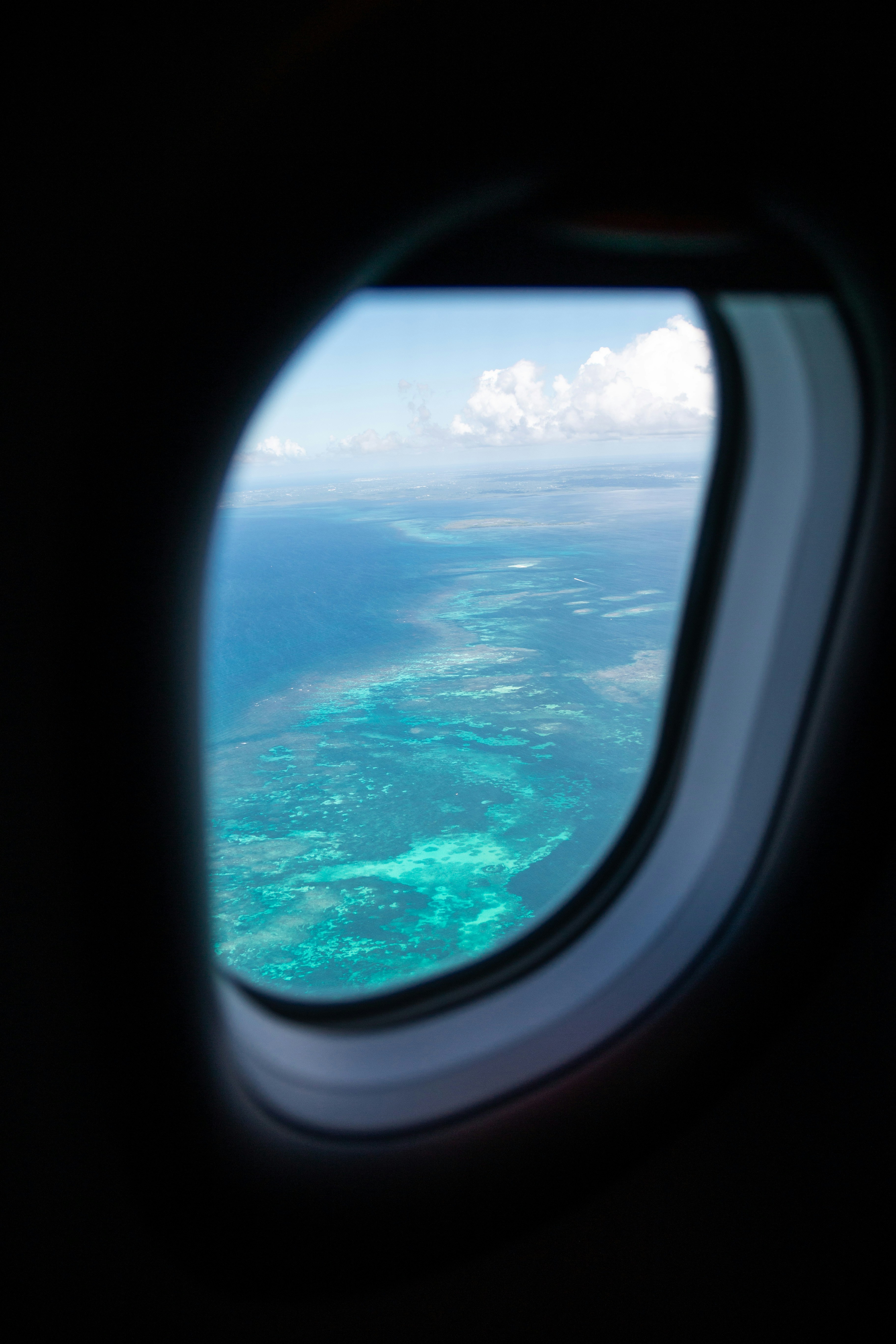 an airplane window with a view of the ocean and the sky
