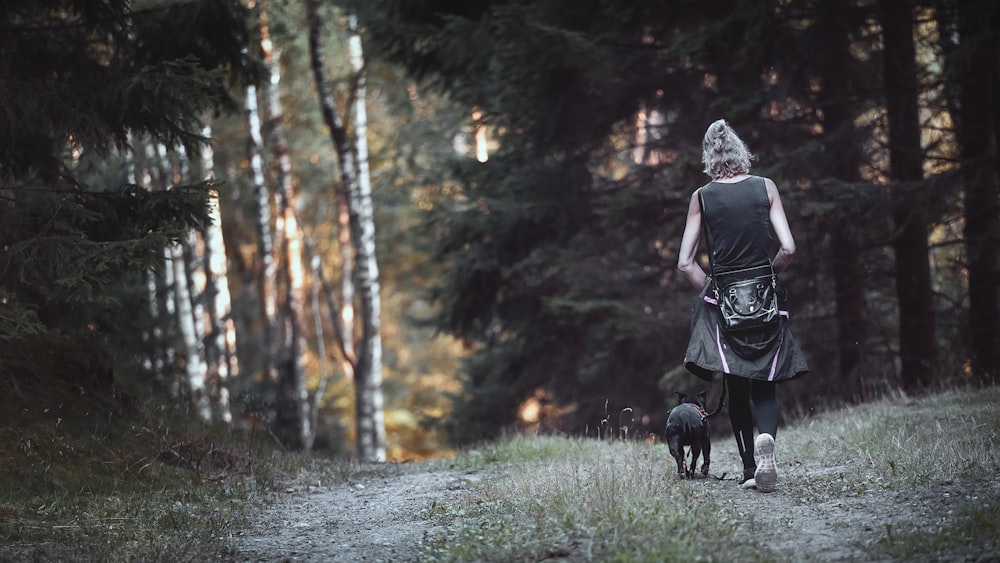 a person walking a dog in the woods