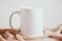 a hand holding a white mug