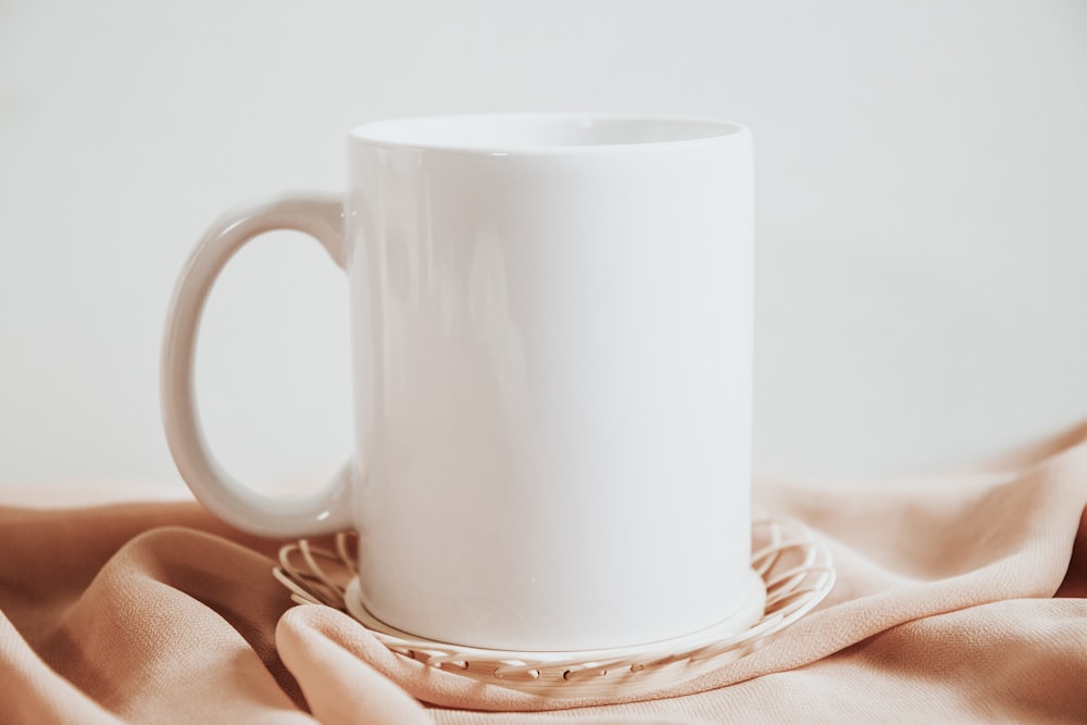 a hand holding a white mug