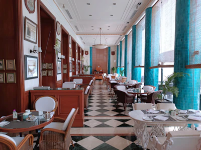Elegant dining area bathed in natural light with teal and white decor reflecting French Riviera style.