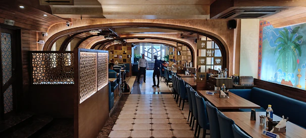 Consultant reviewing restaurant floor plan with owner in a cozy dining space.