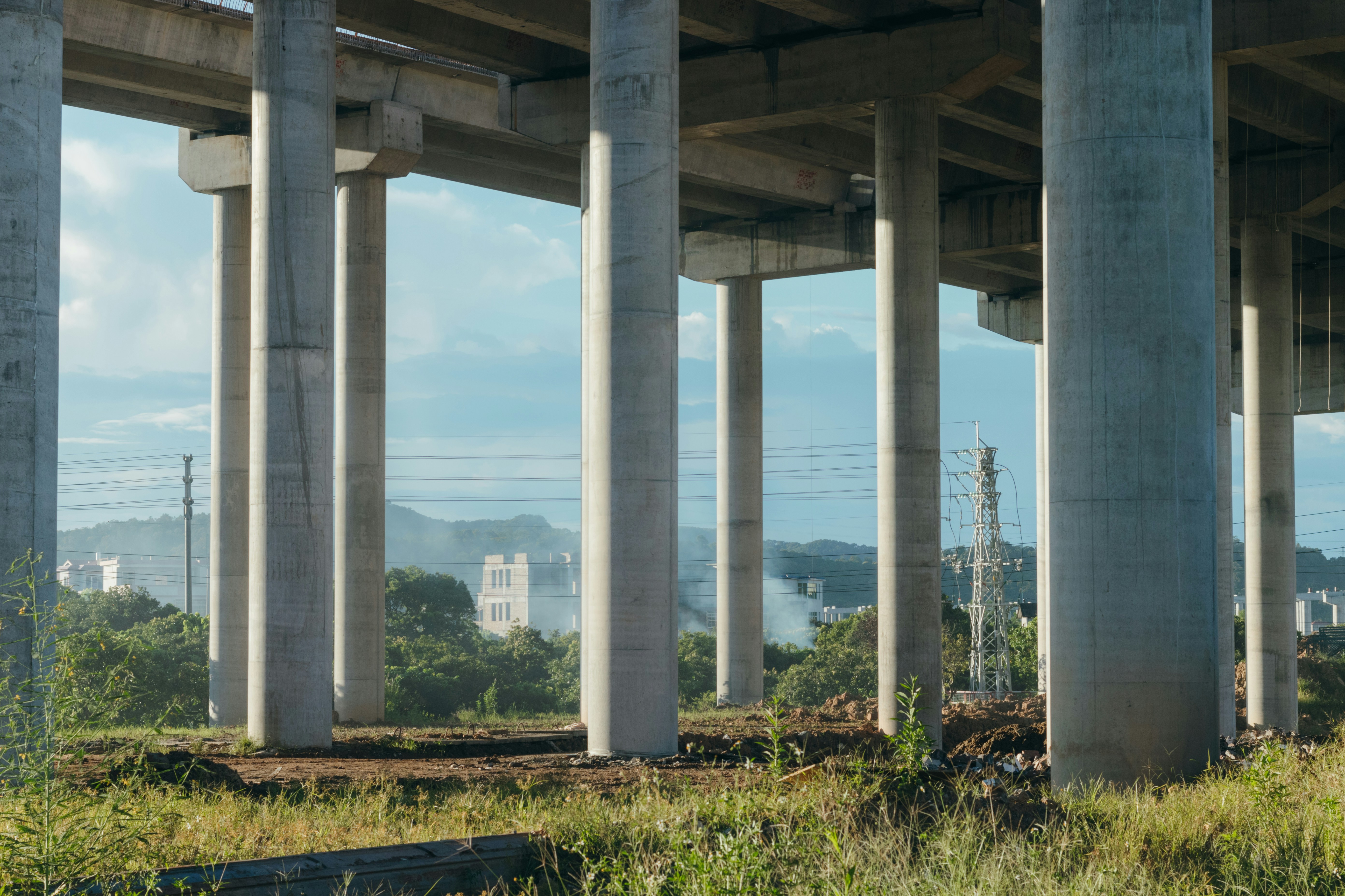 A desolate construction site with unfinished pillars, symbolizing stalled development projects.