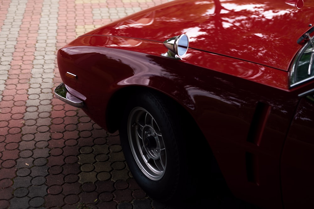 a red car parked on a brick road