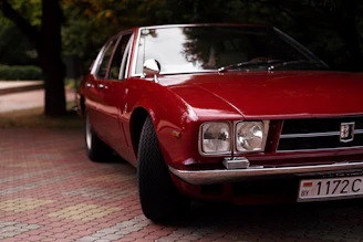 a red car parked on a brick road