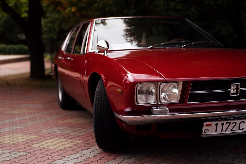 a red car parked on a brick road