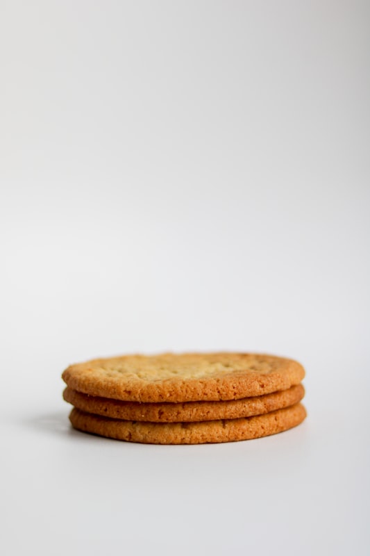 A rustic stack of homemade oatmeal-style cookies on a wooden surface — the cookie component of this cinnamon oatmeal cookie ice cream