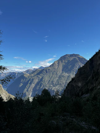 A majestic mountain landscape with clear blue skies and lush greenery