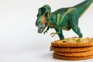 Happy family enjoying dinosaur-shaped cookies and coffee at a wooden table.