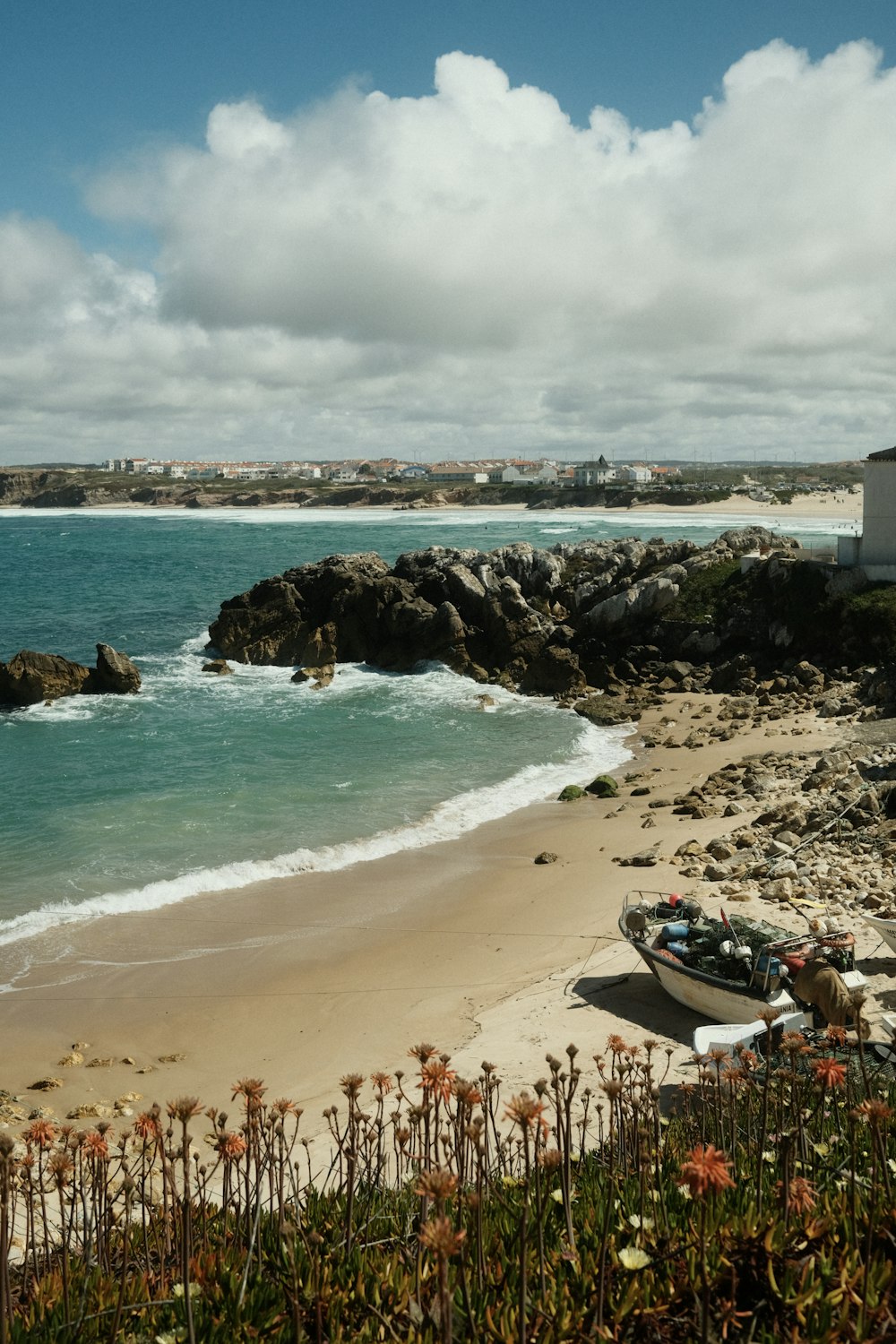 a beach with boats and rocks