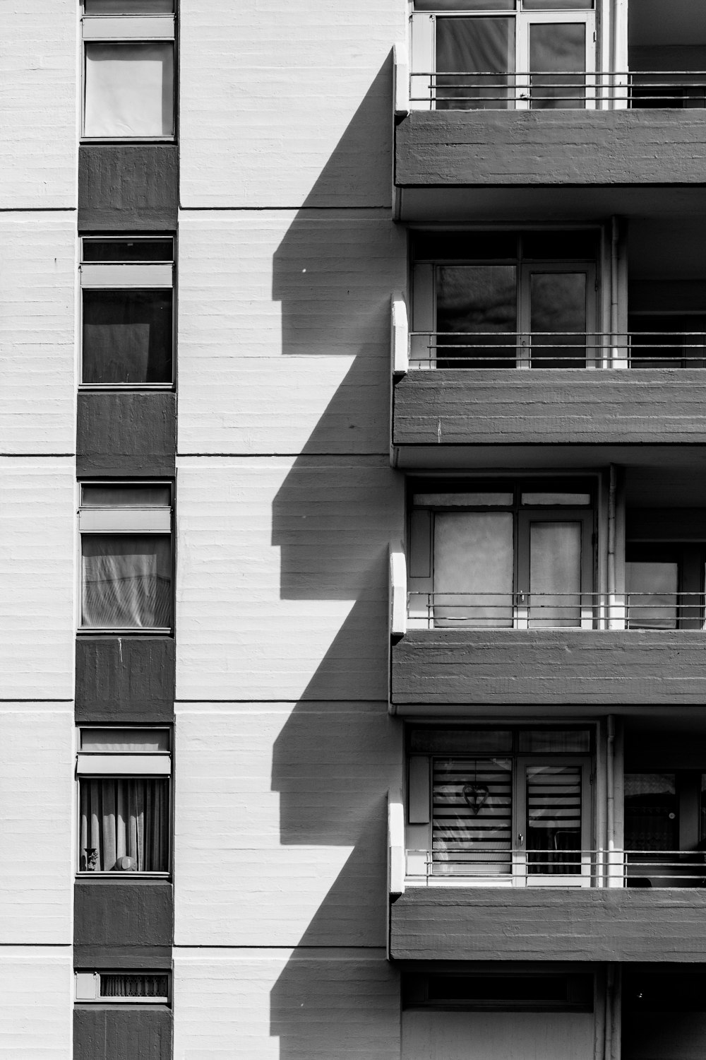 a building with balconies and a shadow on the side