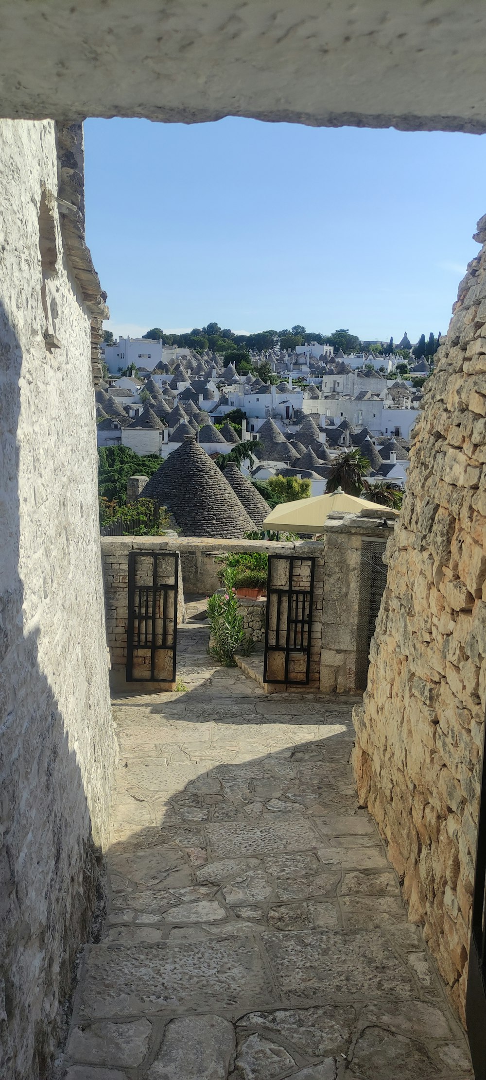 a stone wall with a view of a town and blue sky