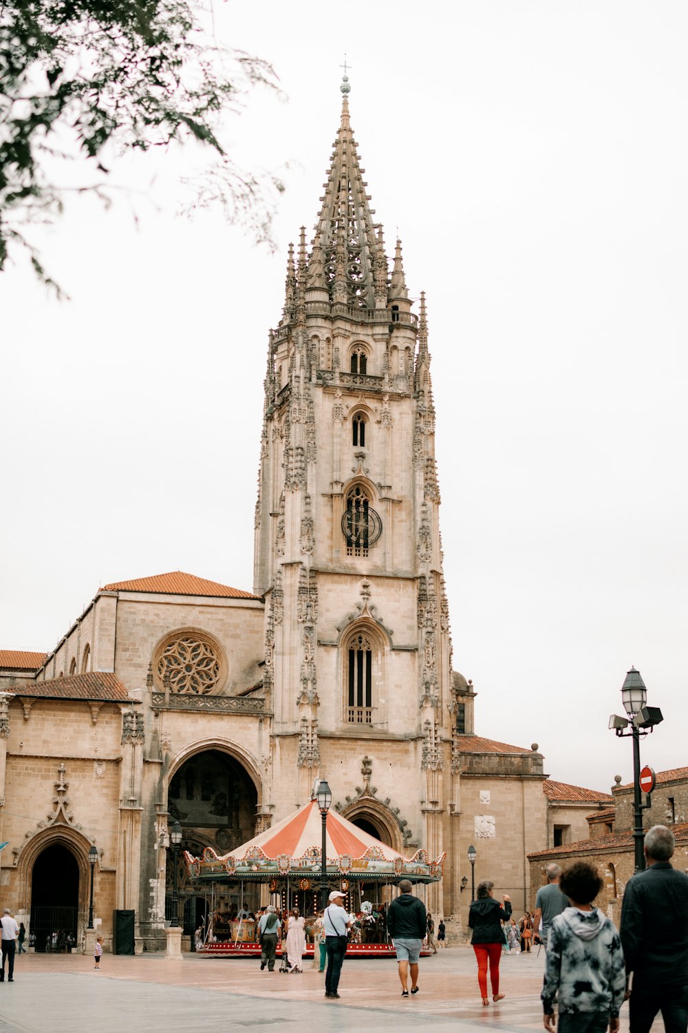 um grande edifício com uma torre do relógio com Oviedo ao fundo