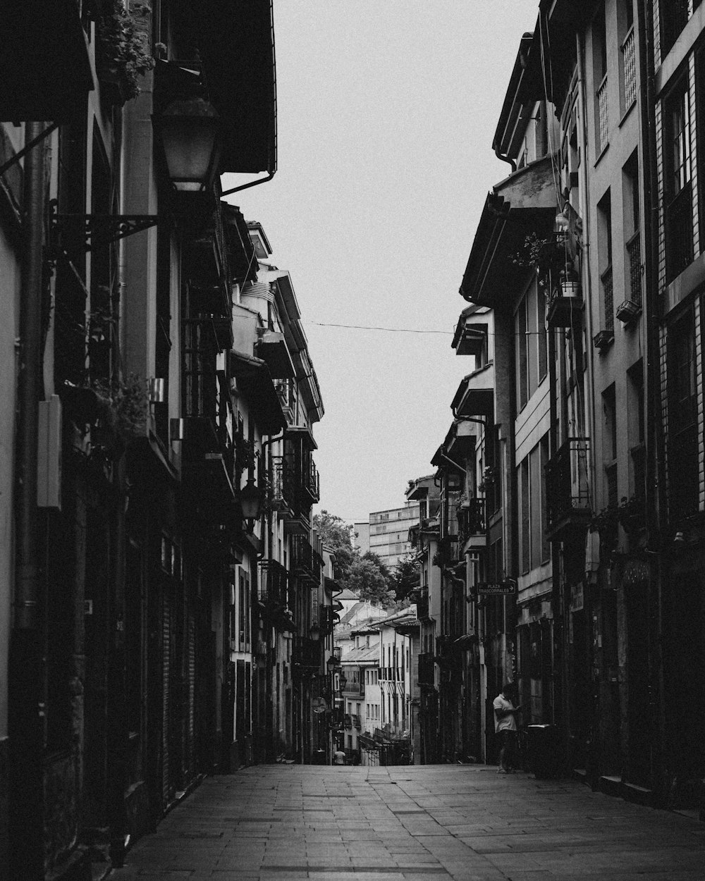 a black and white photo of a street with buildings on both sides