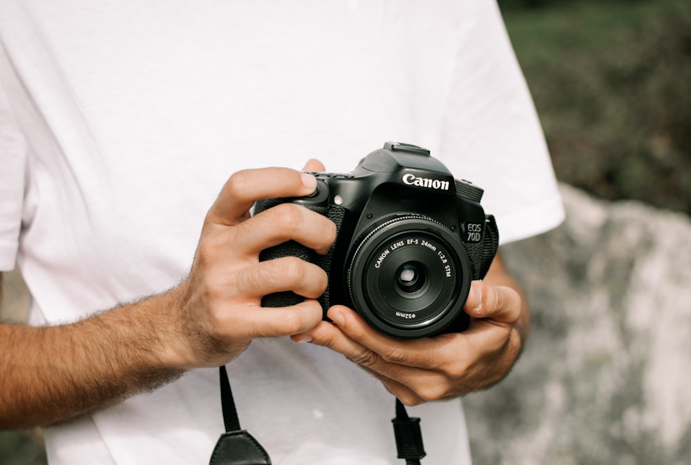 una persona che tiene in mano una macchina fotografica