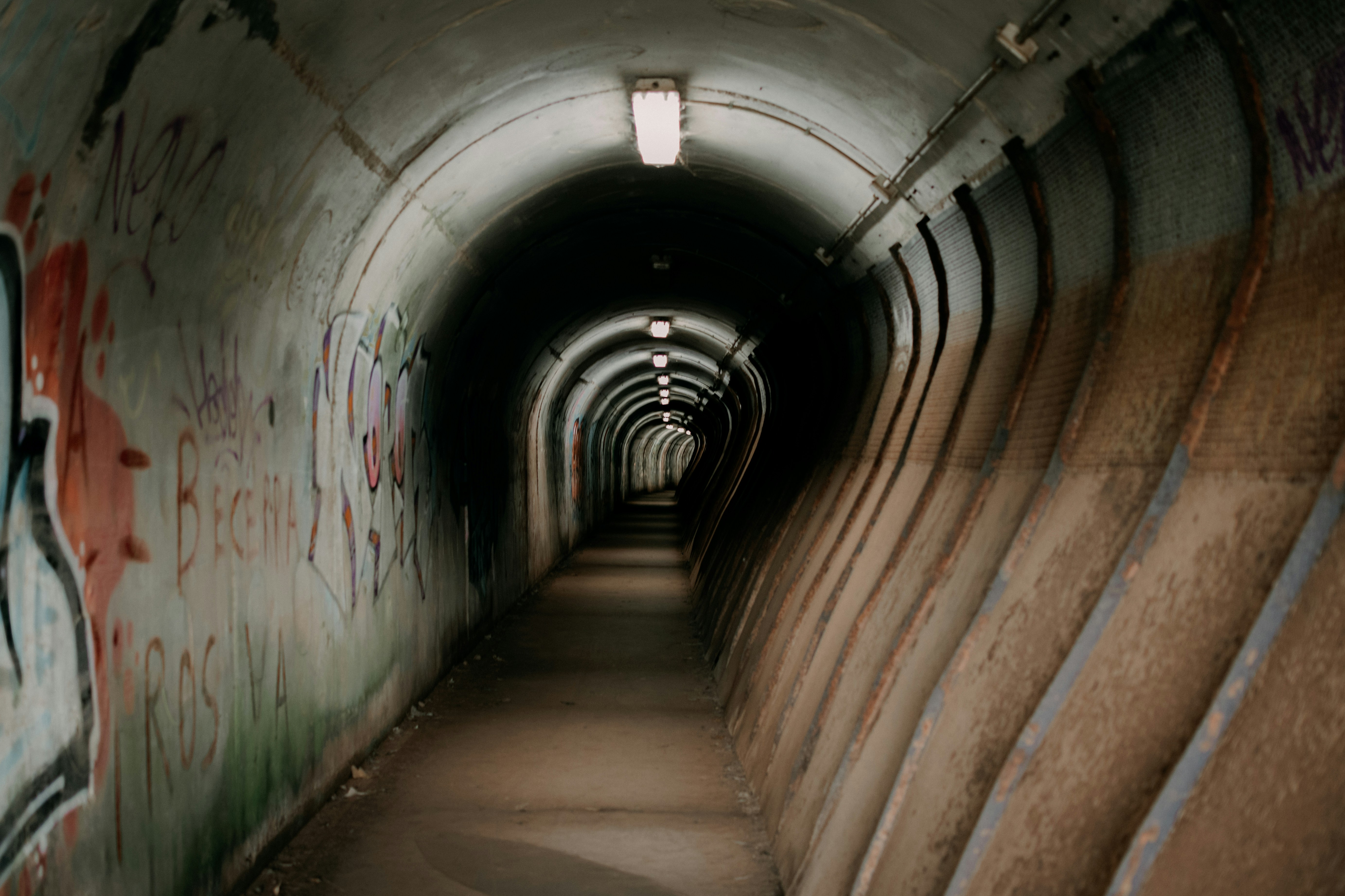 a tunnel with graffiti on the walls, 