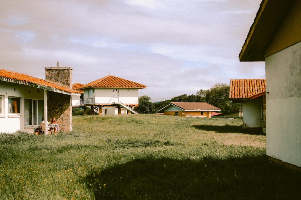 a grassy area with buildings in the background