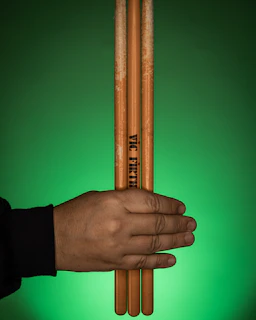 A happy customer holding a new set of drumsticks with a bright smile.