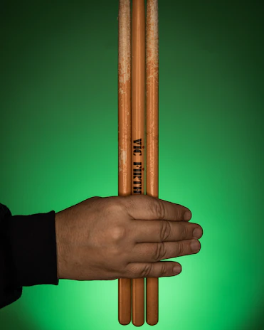 A happy customer holding a new set of drumsticks with a bright smile.