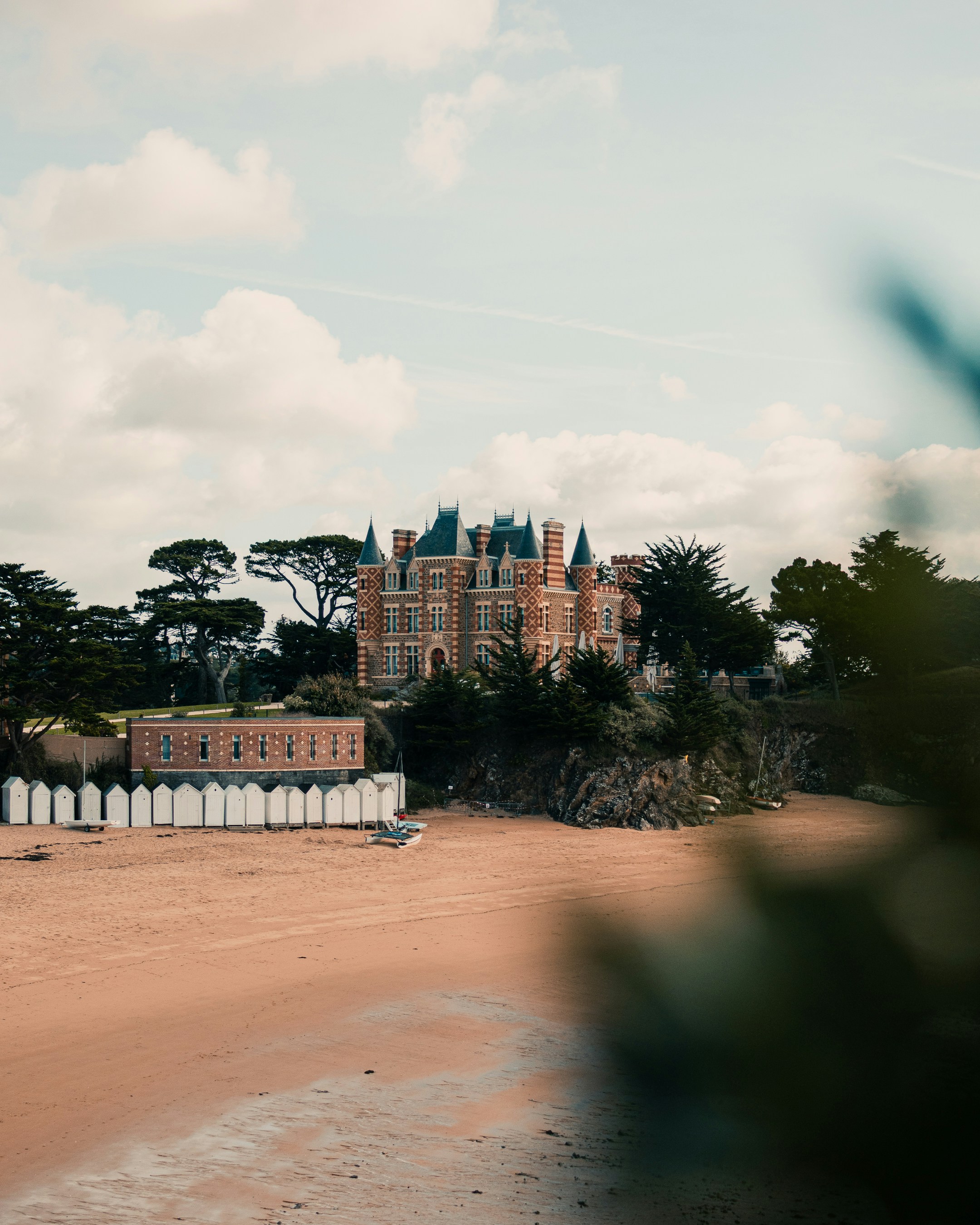 a building with a tower and trees in the front