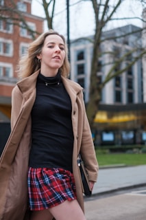 Model wearing a trendy coat walking in an urban setting.