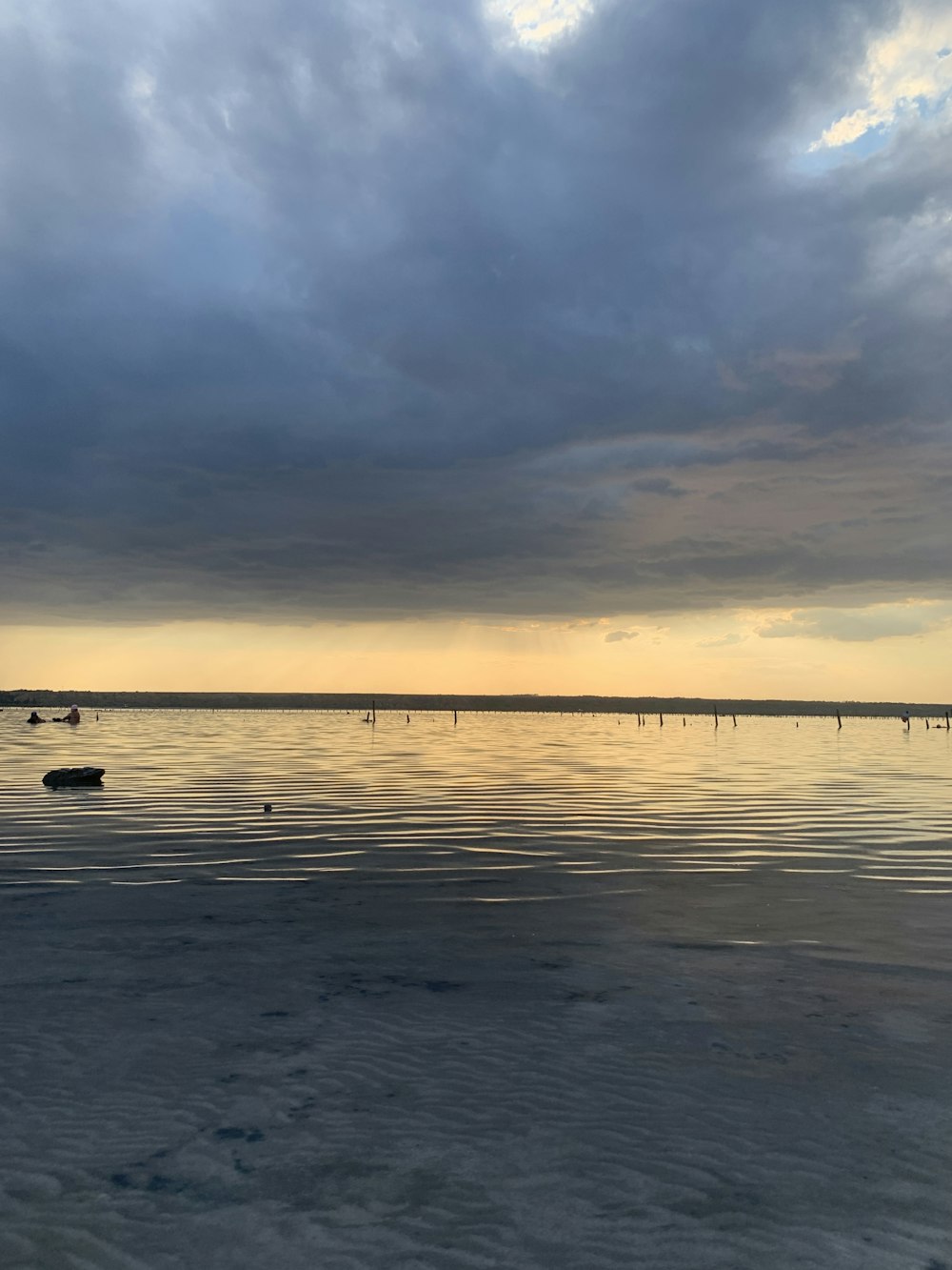 a body of water with a cloudy sky above it