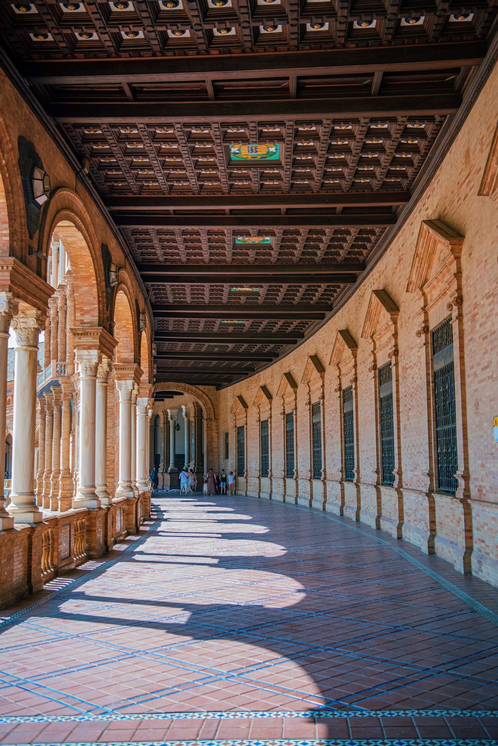 a walkway with pillars and a sign