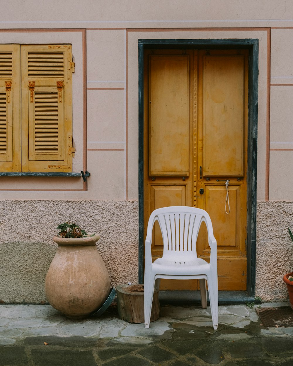 a chair and a pot outside a door