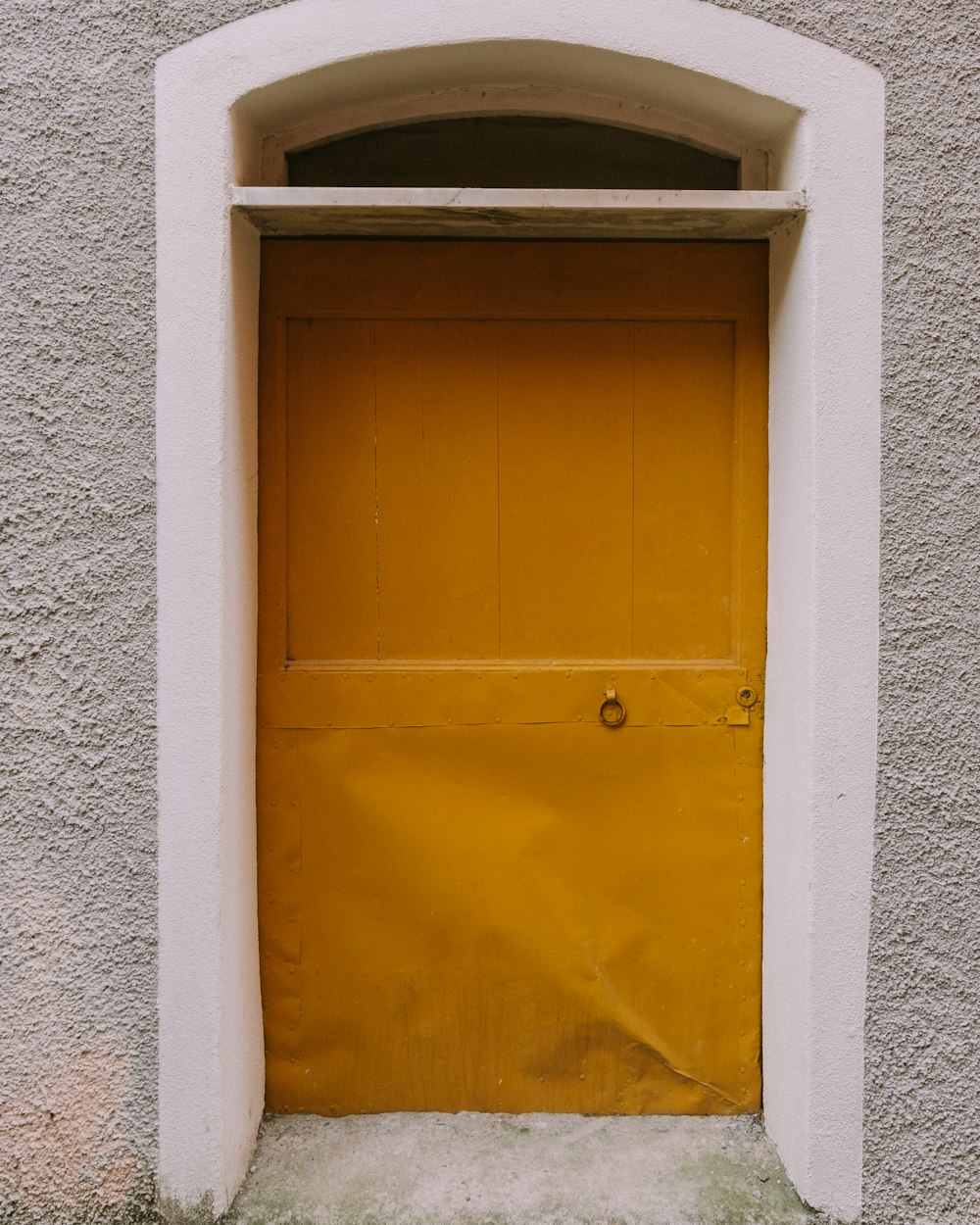 a yellow door in a stone wall