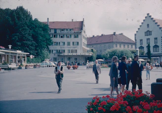 A vibrant community gathering in a village square surrounded by traditional Corsican houses.