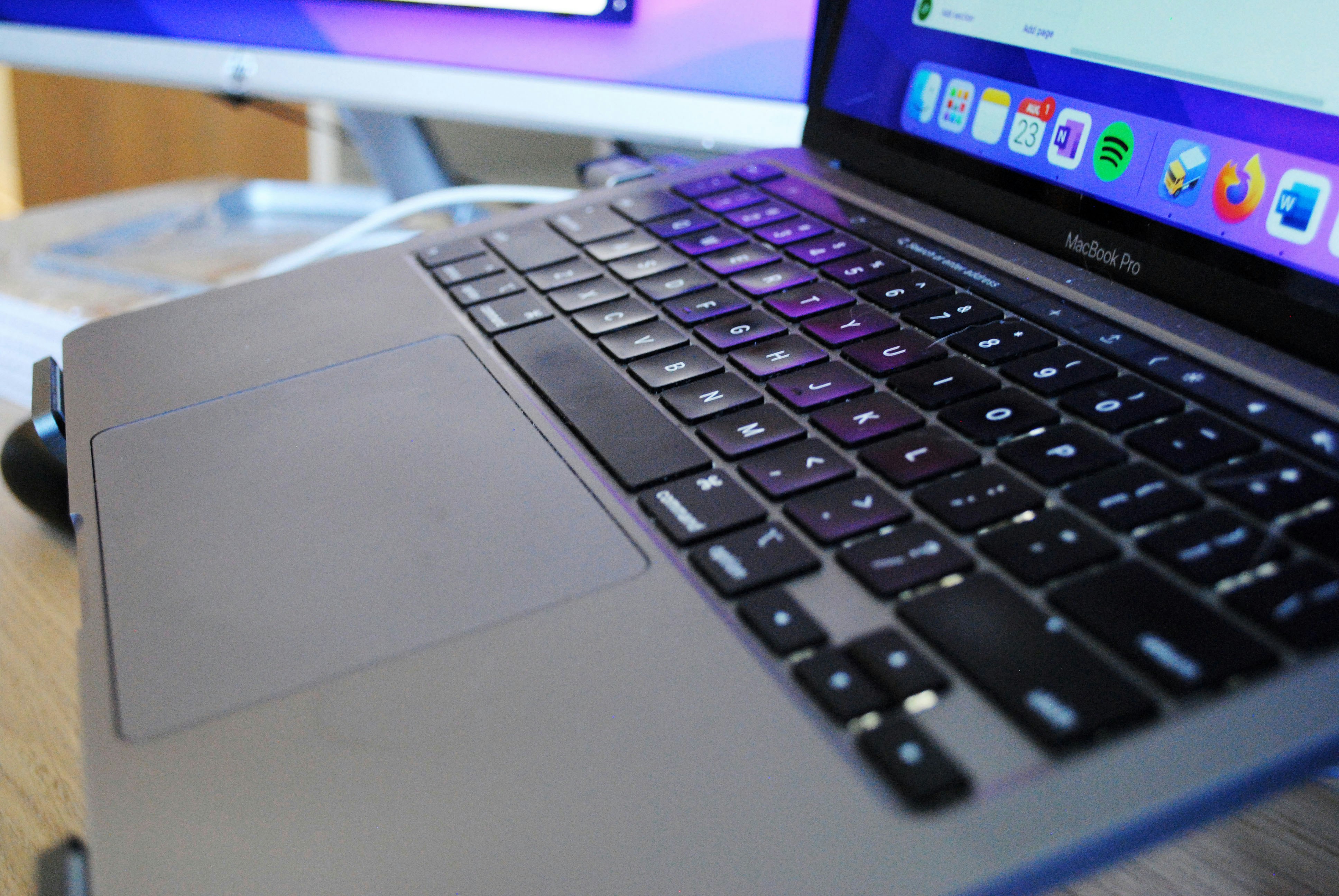 MacBook Pro 16-inch close-up keyboard with atmospheric dark purple-blue lighting