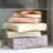Close-up of pastel pistachio-colored soap bars stacked neatly with a soft pink background.