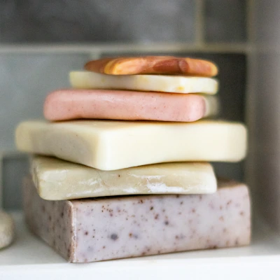 Close-up of colorful handmade soap bars stacked neatly on a wooden surface.