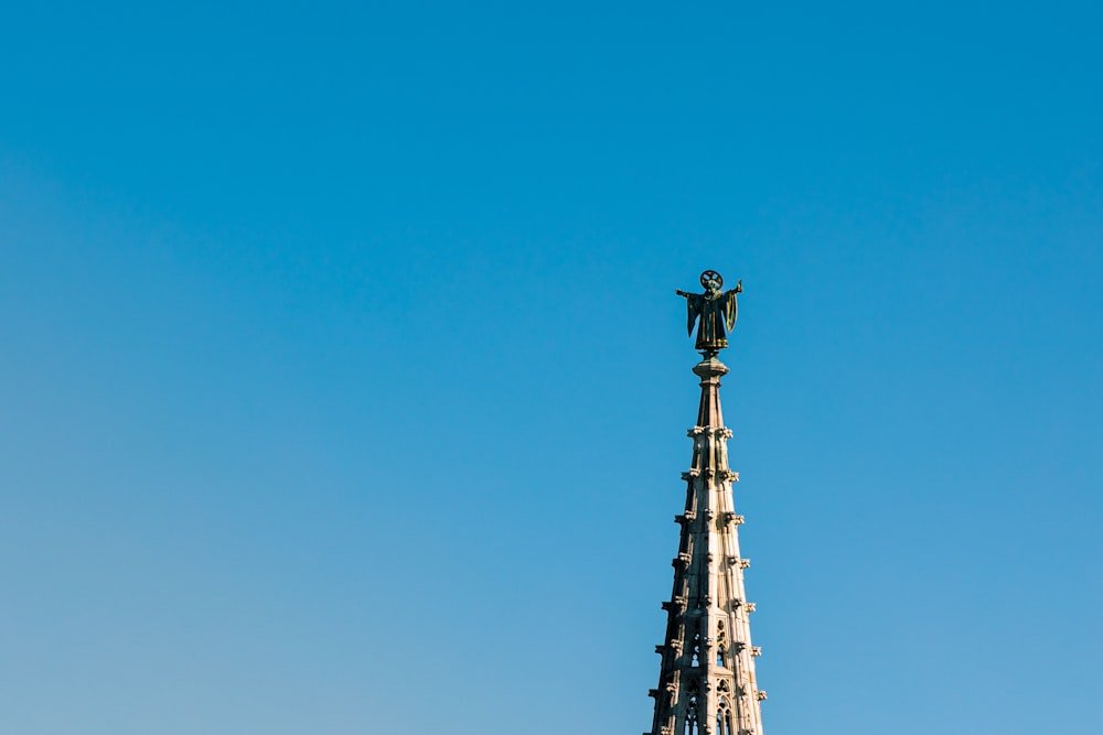 a tall tower with a statue on top