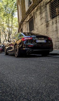 A sleek black sedan parked on a sunlit city street, reflecting Cheney Chen's quality.