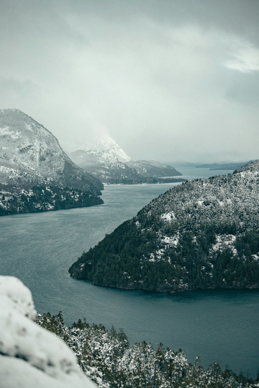 Un cuerpo de agua con montañas cubiertas de nieve en el fondo