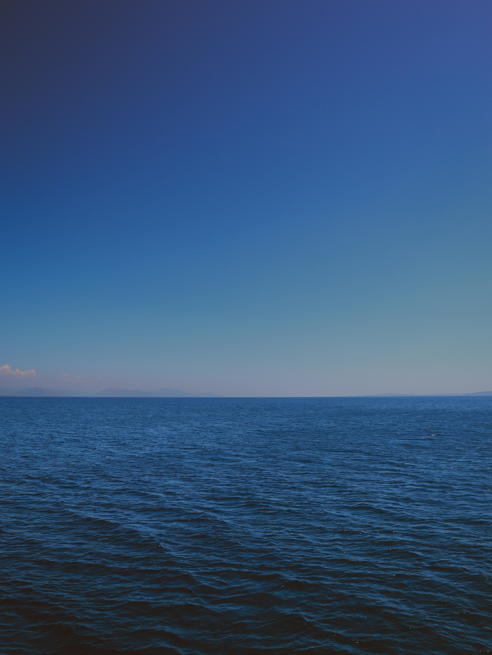 a body of water with a blue sky above it