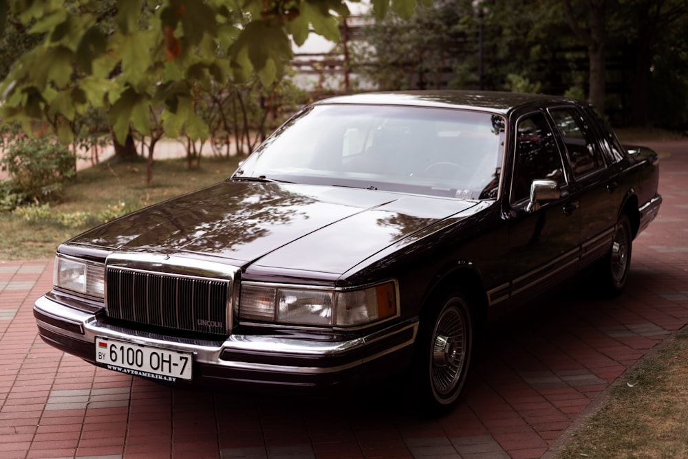 a black car parked on a brick driveway